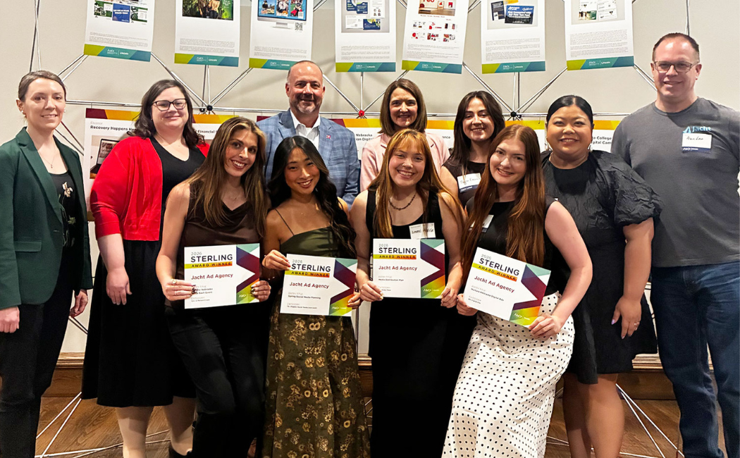 University of Nebraska–Lincoln students, faculty and staff attend the May 7 Prism Awards hosted by the Lincoln American Marketing Association and hold up awards.